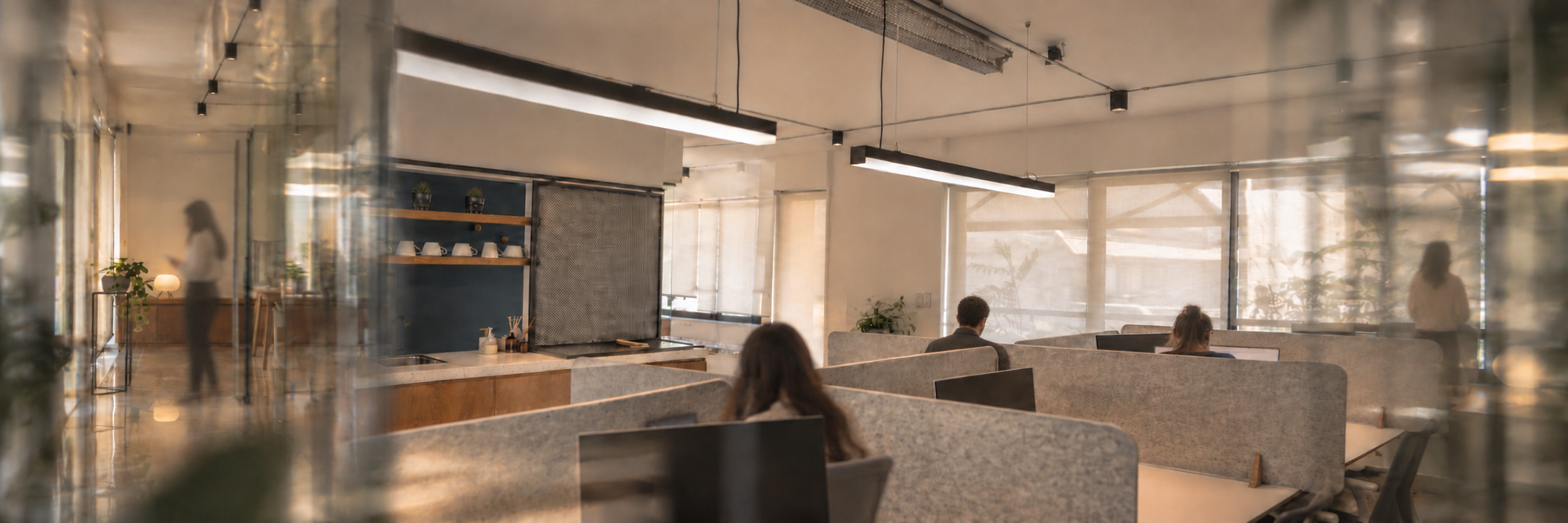 Atmospheric boutique office with indistinct people working behind reflective glass